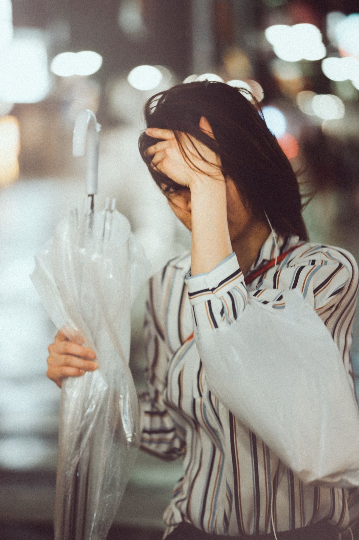 woman protecting her face from the wind.