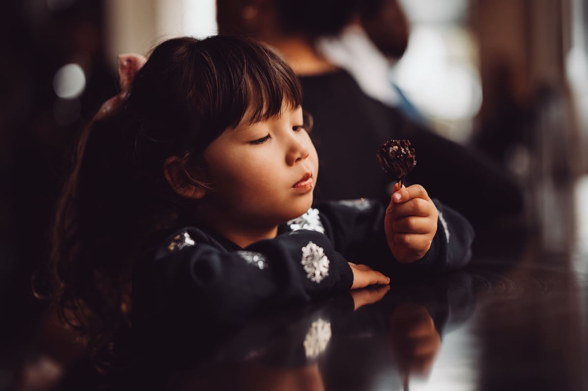 Black and white sample photo of girl Eating a cake pop.