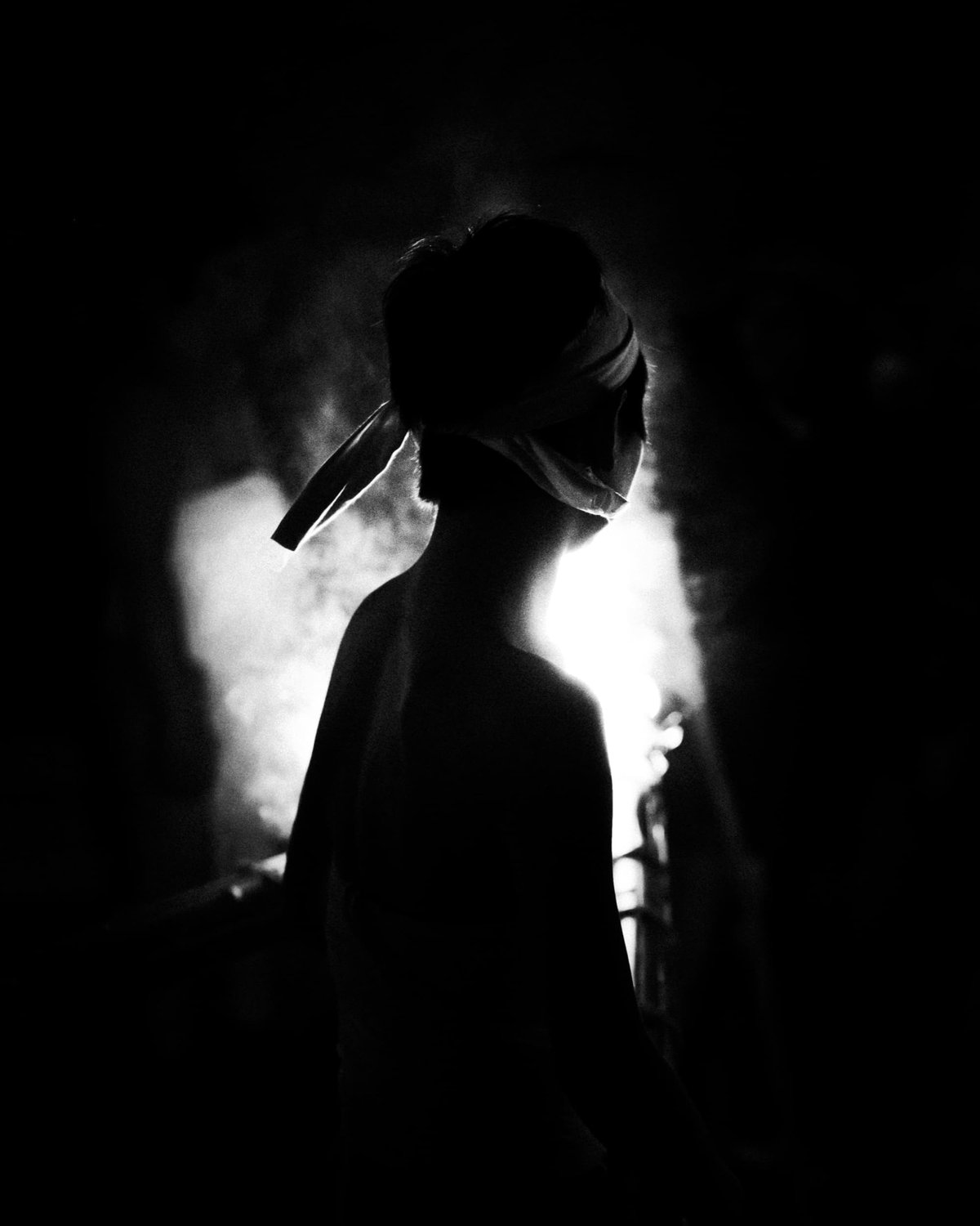 Boy standing in front of fire.