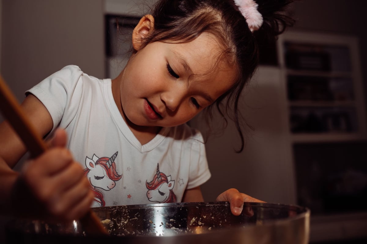 Lifestyle photo sample little girl making cake.