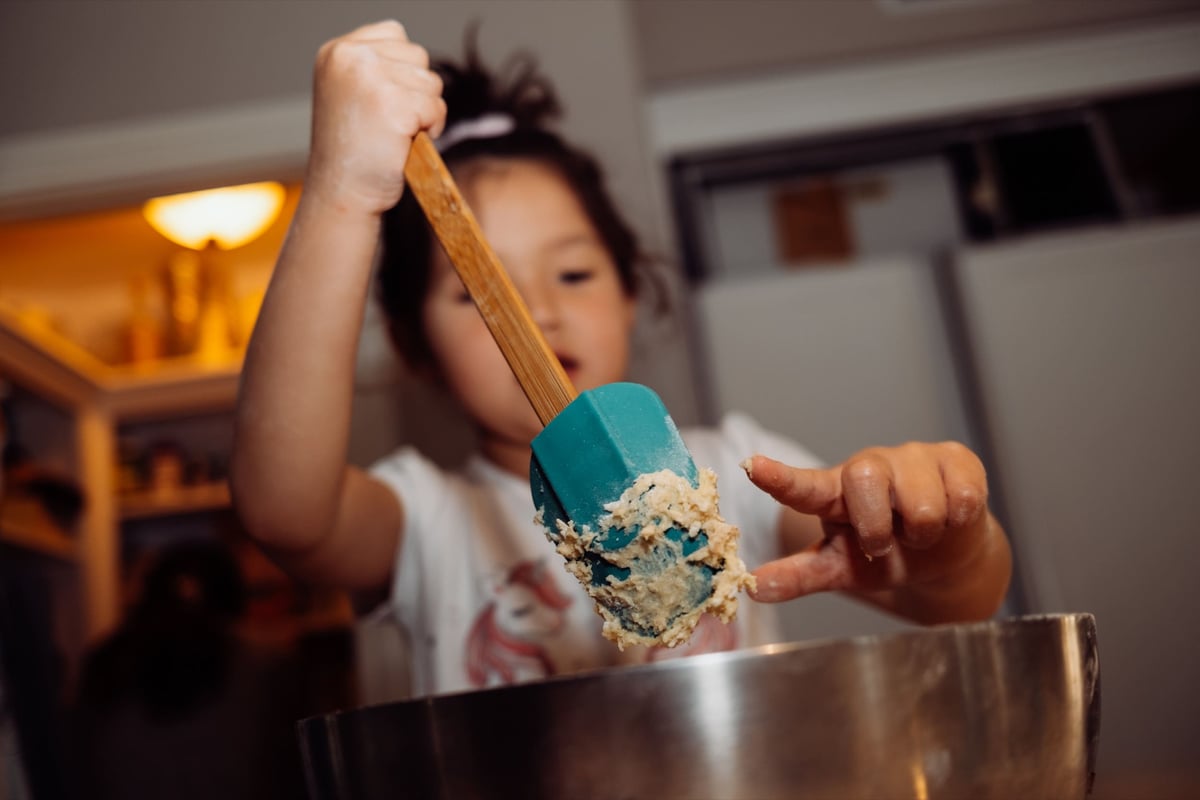 Lifestyle photo sample little girl making cake.