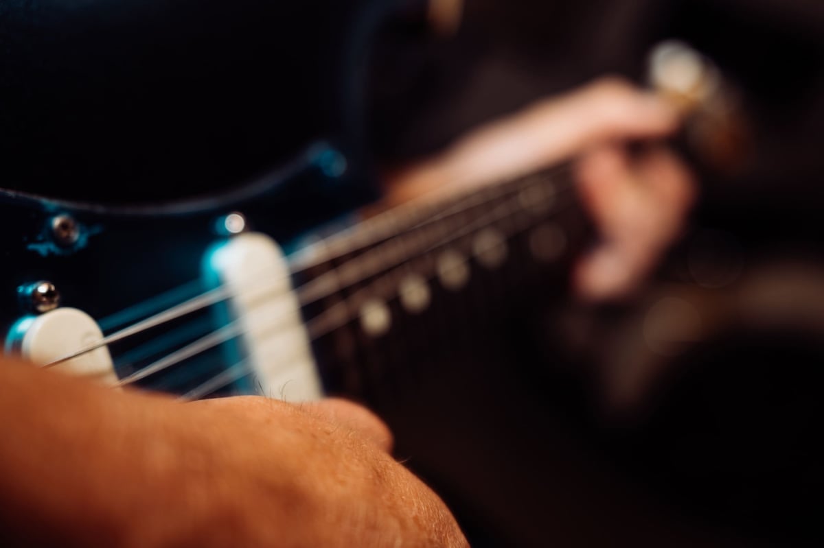 Closeup of hands on a guitar.