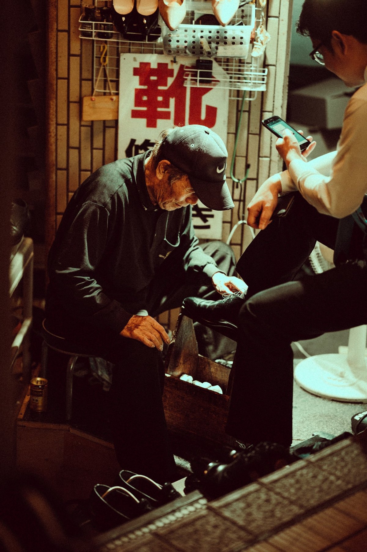 street photo of man polishing shoes.