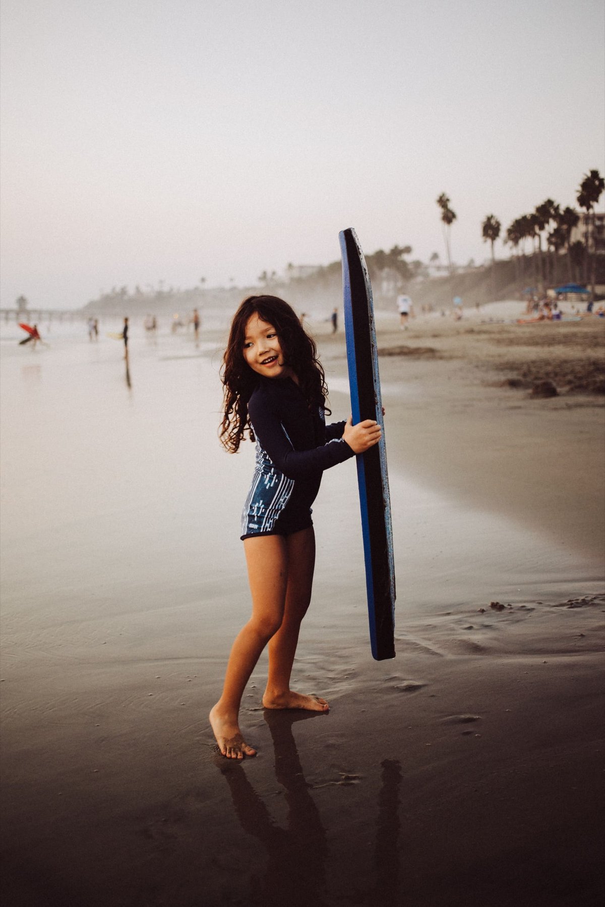 girl holds body board