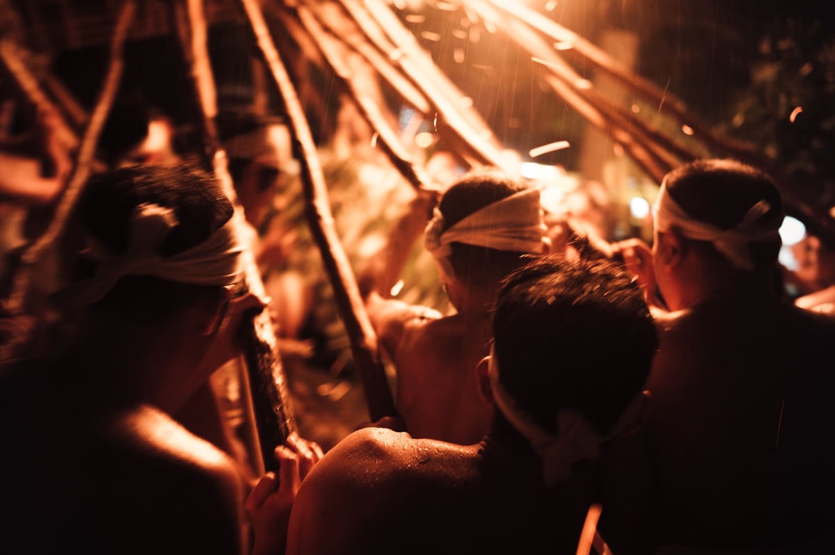 Men working the giant torch at the Oniyo Fire Festival