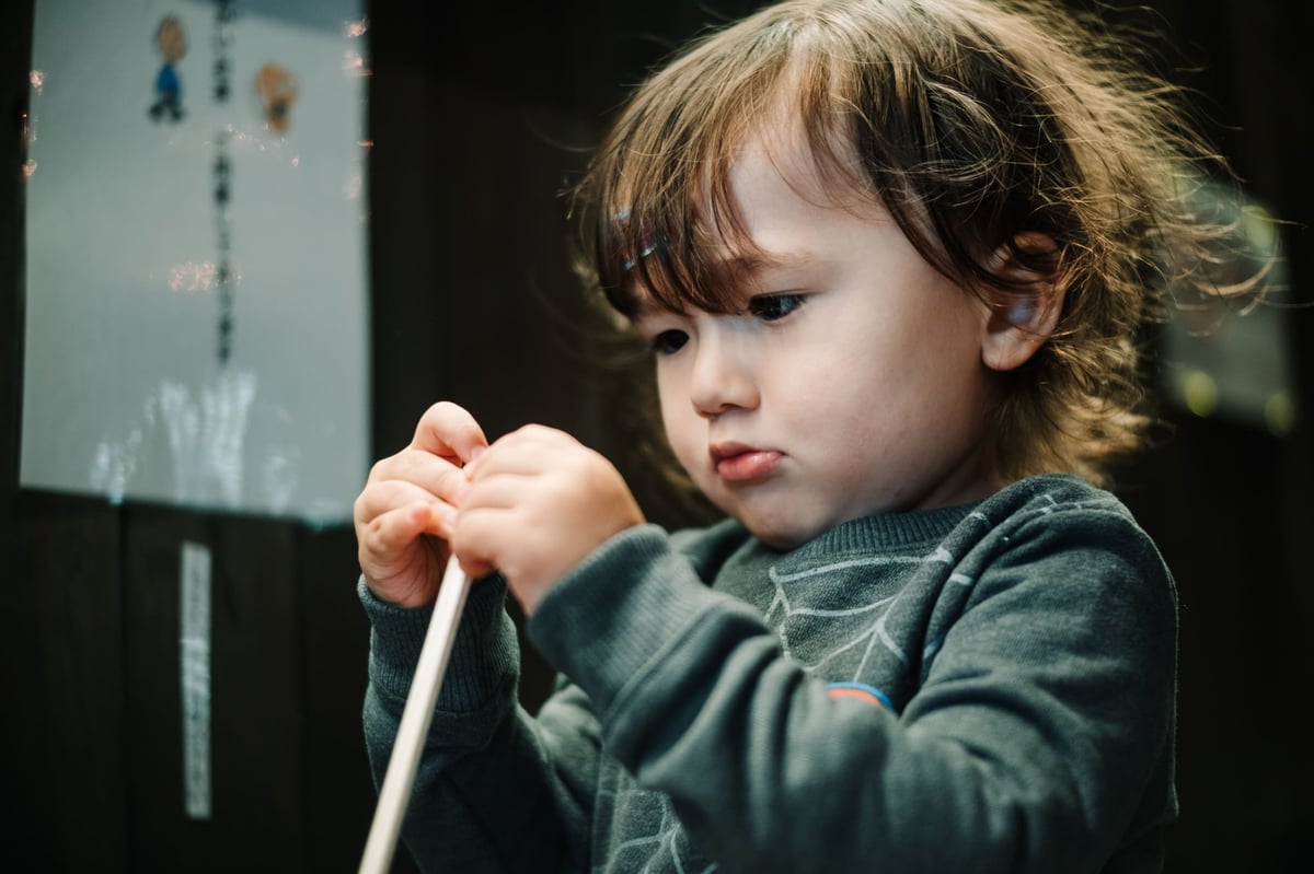 Little boy opening chopsticks.