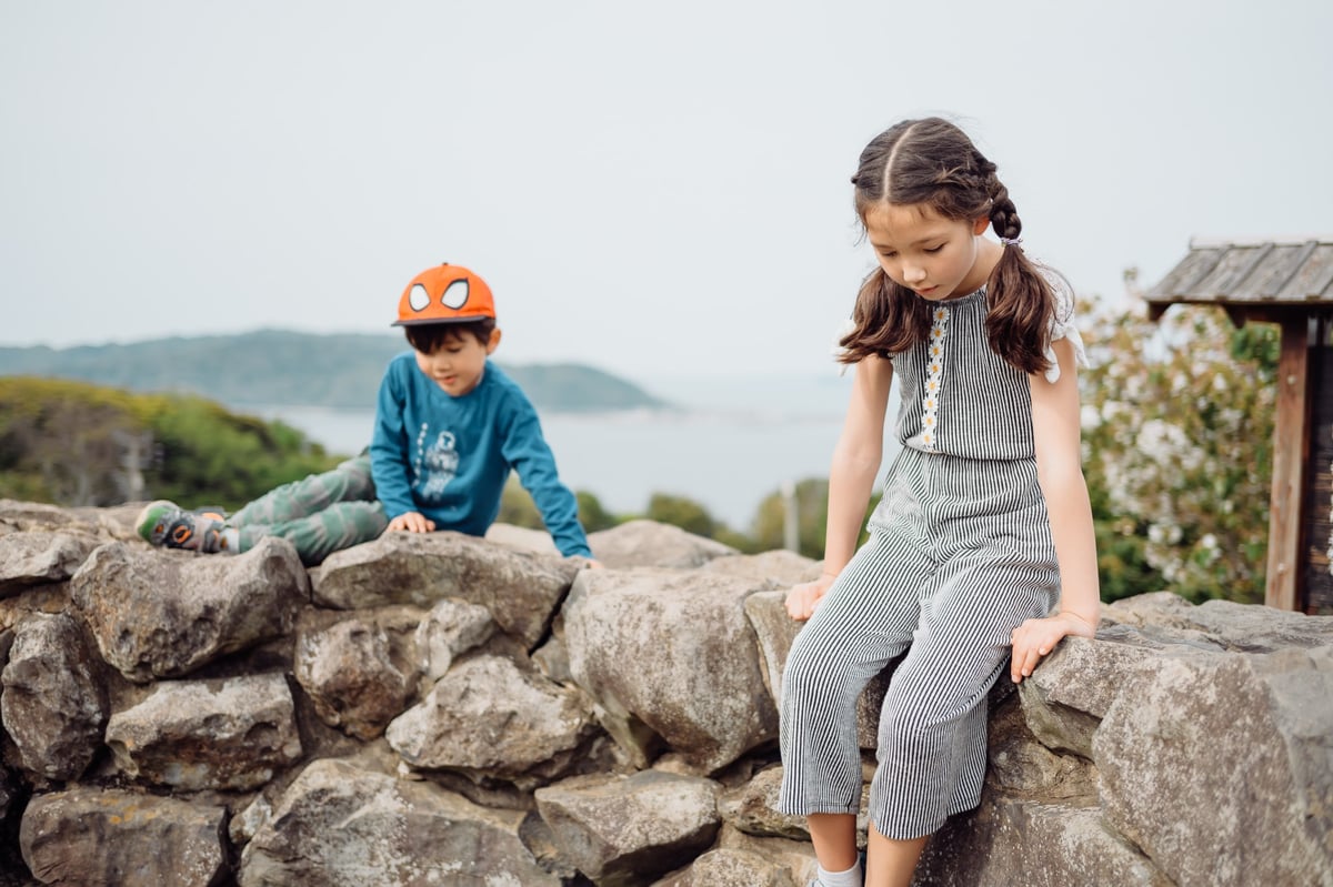 Kids sitting on a stone wall
