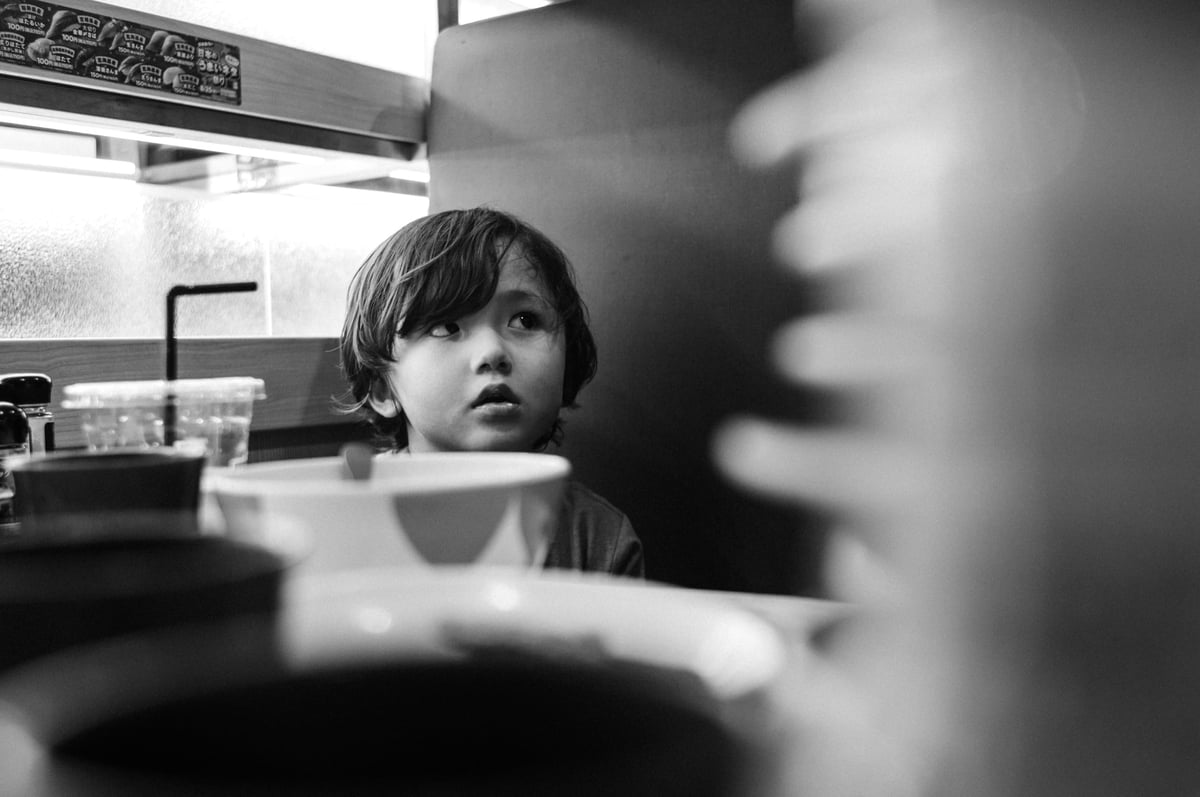 Luka Behind a Stack of Plates