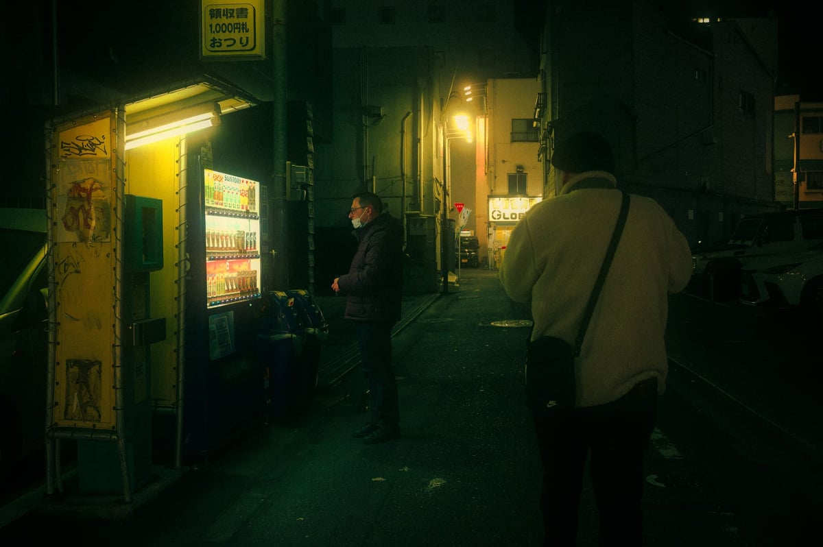 Nakasu street photo looking down an alley with green lighting.