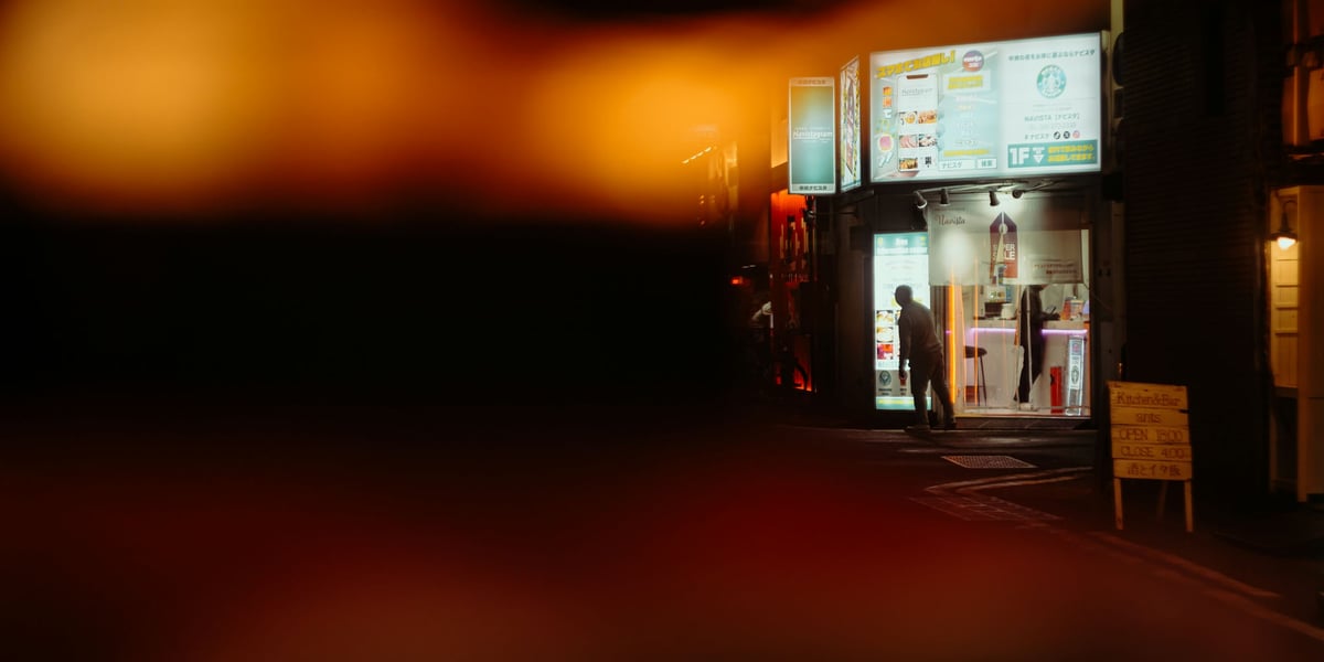 Man peaking out behind two Japanese Lanterns