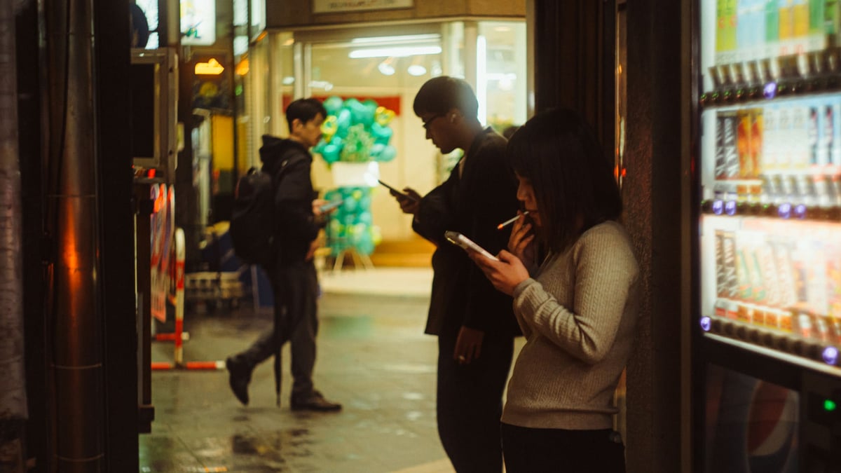 Two people smoking in Nakasu, Shot on the Helios 44-2 48mm f2 lens with the Nikon Z8.