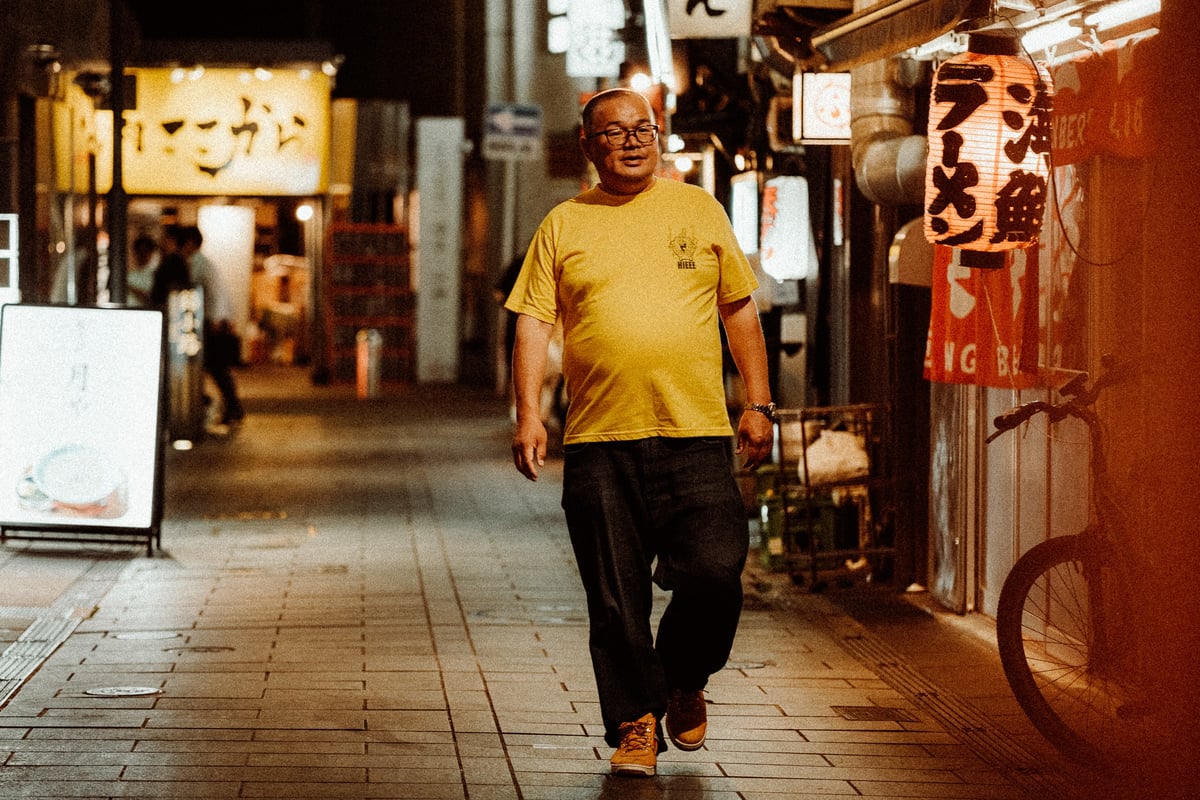 Street photography man walking through Nakasu streets